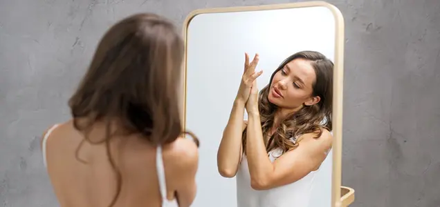 checking smooth skin in mirror after laser hair removal treatment